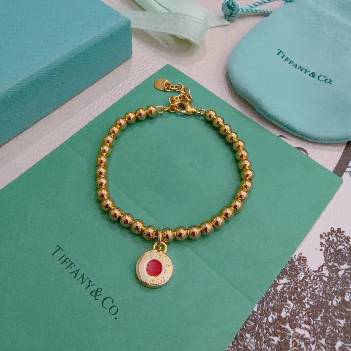 Tiffany & Co. Gold Bead Bracelet with Red Enamel Charm Tiffany & Co. Gold Bead Bracelet with Red Enamel Charm
